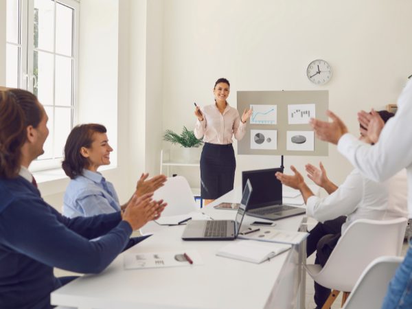 Picture of female colleagues clapping in recognition of their co worker